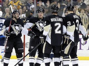 Jan 5, 2014; Pittsburgh, PA, USA; Pittsburgh Penguins defenseman Matt Niskanen (2) celebrates with center Brian Gibbons (L), center Sidney Crosby (LC) and defenseman Olli Maatta (3) after scoring a goal against the Winnipeg Jets during the third period at the CONSOL Energy Center. The Penguins won 6-5. Mandatory Credit: Charles LeClaire-USA TODAY Sports