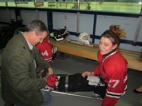 Photo supplied
Danica McPhee gets strapped in by her father Cory for a game of sledge hockey, a sport she has taken up since sustaining a spinal injury in Mexico in February. Danica is trying different sports to stay fit and positive.