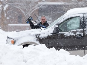 Paul Stark clears snow off his pickup truck in a York Street parking lot in London on Monday. CRAIG GLOVER/The London Free Press/QMI Agency