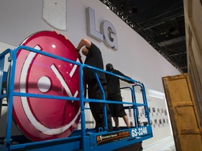 Workers prepare to hang the LG Electronics logo as they build a booth as they prepare for the 2014 Consumer Electronics Show (CES) at the Las Vegas Convention Center in Las Vegas, Jan. 4, 2014. REUTERS/Steve Marcus
