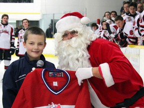 Eight-year-old Malcolm MacGillivary receives the No. 1 item on his Christmas list, a Strathroy Rockets sweater from Santa prior to a game on Dec. 22nd at the West Middlesex Memorial Centre.  The Rockets went on to win the contest by a score of 6-3.
Contributed Photo