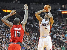 Heat superstar LeBron James shoots over Raptors power forward Amir Johnson during Sunday’s game in Miami. (USA TODAY SPORTS)