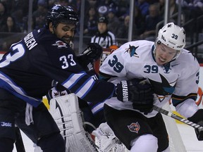 Dustin Byfuglien battles with Logan Couture during NHL action Nov. 10, 2013. (Kevin King/Winnipeg Sun/QMI Agency)