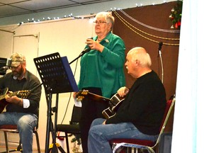 Lynda Moses introduces Phil Willis and Ray McMillian, two of the many entertainers who volunteered at the 18th Ron Moses Christmas Dinner on Dec. 25.