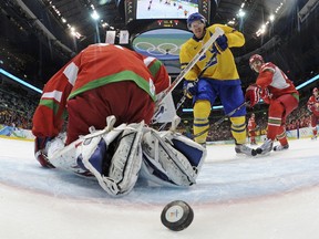 Sweden's Daniel Alfredsson scores on Belarus goaltender Andrei Mezin during the third period of their men's preliminary round ice hockey game at the Vancouver 2010 Winter Olympics February 19, 2010. (REUTERS/Bruce Bennett/Pool)