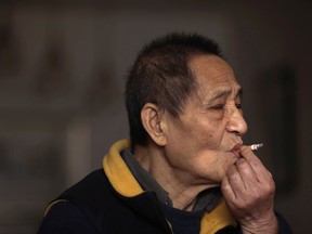 Bao Tong, former member of the Central Committee of the Communist Party of China, smokes at home during an interview in Beijing, in this February 20, 2013 file photo. . REUTERS/Petar Kujundzic/Files (