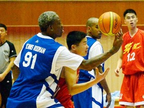 Former NBA star Dennis Rodman (left) fights for the ball during an international exhibition game between the U.S. and North Korea in Pyongyang, in this photo released by Kyodo on Wednesday, Jan. 8, 2014. (Reuters/Kyodo)