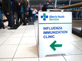 People line up for flu shots at the Northgate Health Clinic in Edmonton, Alta., on Sunday Jan. 5, 2014. Perry Mah/QMI Agency