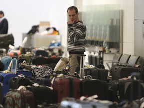 Travellers at Pearson International Airport's Terminal 1 go through the baggage room on Jan. 8, 2014 looking for luggage that has been misplaced because of flight cancellations over the past few days related to the weather. (Jack Boland/Toronto Sun)