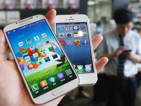 Samsung Electronics' Galaxy S4 (L) and Apple's iPhone 5 are seen in this file picture illustration taken in Seoul on May 13, 2013. REUTERS/Kim Hong-Ji/Files