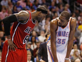 Miami Heat's forward LeBron James talks to Oklahoma City Thunder's forward Kevin Durant during a free throw attempt by a Thunder player in the second half of their NBA basketball game in Oklahoma City, Oklahoma February 14, 2013. (REUTERS/Bill Waugh)