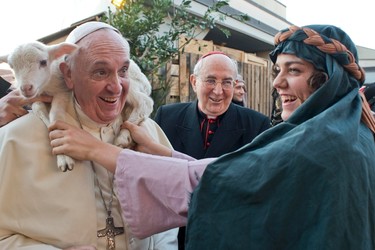 A woman dressed as a character from the nativity scene puts a lamb around the neck of Pope Francis as he arrives to visit the Church of St Alfonso Maria dei Liguori in the outskirts of Rome January 6, 2014. Picture taken January 6, 2014. REUTERS/Osservatore Romano