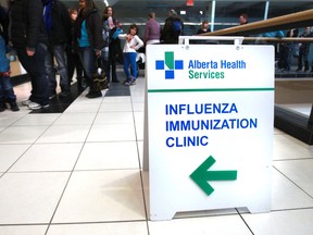 Albertans wait in line to receive their flu vaccine at a Health Clinic on Jan. 5. - QMI Agency