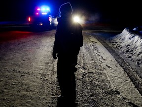An RCMP member mans a road block along Range Road 192 near Township Road 525, north of Tofield Alta., on Jan. 6, 2013. Two Mounties were injured in a violent encounter at a rural property nearby. RCMP confirmed one officer was shot and another was run over by a vehicle. David Bloom/QMI Agency