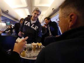 U.S. Secretary of State John Kerry offers cupcakes to members of the travelling press between Washington and the Middle East, November 2, 2013. (REUTERS/Jason Reed)