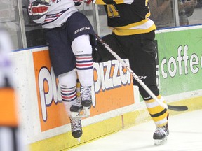 Frontenacs' Slater Doggett takes Oshawa's Bradley Latour into the boards  during Friday night's OHL game at the Rogers K-Rock Centre. (Michael Lea/The Whig-Standard)