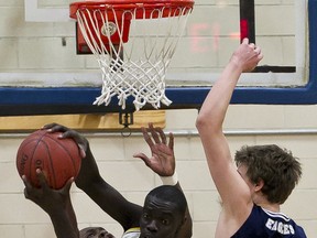 Marial Shayok formerly of St. Patrick's pulls down a rebound against Adam Voll of St. Mary's during play in the OFSAA AAAA Boys Basketball Championships. Tuesday March 6,2012. (ERROL MCGIHON/THE OTTAWA SUN/QMI AGENCY).