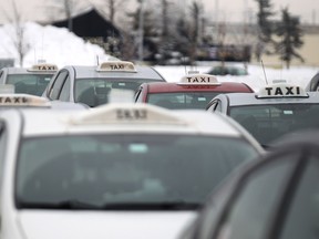 Taxicabs queue at the Winnipeg James Armstrong Richardson International Airport in Winnipeg, Man., on Sat., Jan. 11, 2014. The province expects to put the onus on ensuring patients discharged from the hospital and leaving by cab arrive home safely on the drivers. Kevin King/Winnipeg Sun/QMI Agency