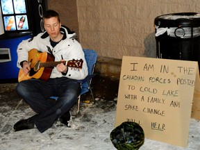 Cpl. Darenn Tremblay, 25, performed Thursday on a sidewalk with a guitar, an up-ended combat helmet and a sign saying, "I am in the Canadian Forces posted to Cold Lake with a family. Any spare change will help." (FILE PHOTO)