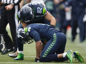 Seattle Seahawks wide receiver Percy Harvin (bottom) is looked at by tight end Luke Willson (82) after Harvin was hit by New Orleans Saints free safety Rafael Bush (not pictured) during the first half of the 2013 NFC divisional playoff football game at CenturyLink Field. (Joe Nicholson-USA TODAY Sports)