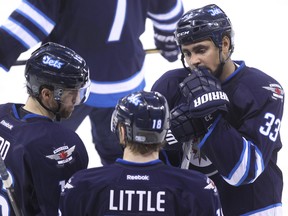 Winnipeg Jets forward Dustin Byfuglien (right) speaks with linemates Andrew Ladd (left) and Bryan Little during a break in play against the Columbus Blue Jackets during NHL action at MTS Centre in Winnipeg, Man. on Sat., Jan. 11, 2014. Kevin King/Winnipeg Sun/QMI Agency