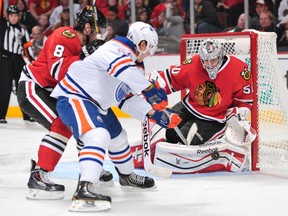 Nov 10, 2013; Chicago, IL, USA; Chicago Blackhawks goalie Corey Crawford (50) makes a save against Edmonton Oilers right wing Nail Yakupov (64) during the third period at the United Center. The Blackhawks beat the Oilers 5-4. Mandatory Credit: Rob Grabowski-USA TODAY Sports