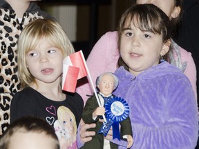 Abby Gabriel, left, and Katrina Cordeiro, Grade 1 students from Saint Marguerite Bourgeoys Catholic School, sing with the special events choir at the 199th birthday celebration for Sir John A. Macdonald in Memorial Hall on Saturday. Julia McKay The Whig-Standard