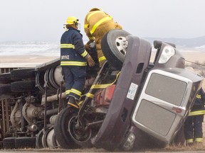Fire crews from Pincher Creek and Lundbreck extricate the driver from a toppled semi on Highway 22, the latest victim of high winds on the notorious stretch of road. Greg Cowan photo/QMI Agency