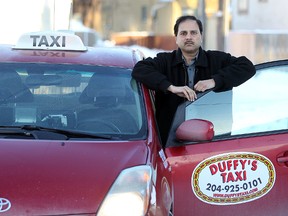 Ram Valluru, general manager of Duffy's Taxi is seen with one of his cabs in Winnipeg, Man. Monday, Jan. 13, 2014. (Brian Donogh/Winnipeg Sun)