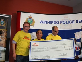 Winnipeg Chief of Police Devon Clunis accepts a donation of $20,000 to the Winnipeg Police Service Endowment Fund from One Heart Winnipeg. (KRISTIN ANNABLE/Winnipeg Sun)