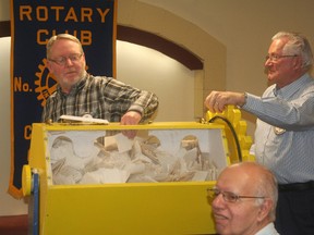 Rotary Club of Chatham member Les Herman pulls out the winning ticket on Jan. 15 for the club's 13th Mustang draw as fellow Rotarian and ticket drum spinner Andy Watson looks on. Dan Kelly of Chatham was the lucky winner of a 1965 Mustang. Ed Robbins (foreground) sold the winning ticket.