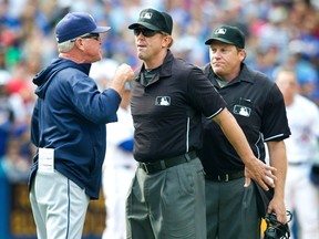 First base umpire Jeff Kellogg steps between Tampa Bay Rays manager Joe Maddon arguing with home plate umpire Paul Schrieber in the seventh inning of their American League MLB baseball game against the Toronto Blue Jays in Toronto September 29, 2013. (REUTERS/Fred Thornhill)