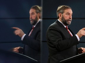 New Democratic Party leader Thomas Mulcair is reflected on a screen while speaking during a news conference in Ottawa December 18, 2013. (REUTERS/Chris Wattie)