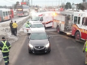 Emergency workers check on the driver of a blue Civic Wednesday morning, after the car was T-boned by a city bus at the intersection of Woodroffe and Hunt Club. A 54-year-old OC Transpo bus driver was charged with failing to stop at a red light. (submitted photo)
