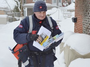 Jim Moodie/The Sudbury Star
Postal worker Pierre Lapointe delivers mail to residences on John Street on Thursday.