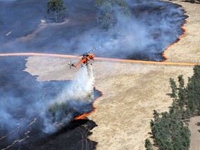 A helicopter dumps water on a bushfire burning in the Grampians bushland in the southeastern Australian state of Victoria, about 300 km (186 miles) west of Melbourne, January 17, 2014. REUTERS/Country Fire Authority (CFA)/Handout via Reuters