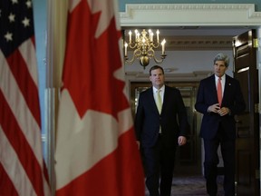 United States Secretary of State John Kerry (R) walks to a joint statement with Canada's Foreign Minister John Baird at the State Department in Washington January 17, 2014.    REUTERS/Gary Cameron