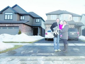 Ryan and Brittany Broll stand outside their new home on Buroak St. with 18-month-old daughter, Charlotte, and their dog, Cae, in London. CRAIG GLOVER/The London Free Press/QMI Agency