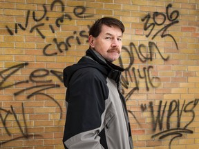 Vanier Community Church associate pastor Doug Stringer poses for a photo near graffiti that was discovered Tuesday morning. January 15, 2014. Errol McGihon/Ottawa Sun