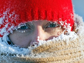 Ice from the breath of Gail Davis forms around her face as she exercises by walking outside in Minneapolis, January 8, 2014. (REUTERS/Eric Miller)