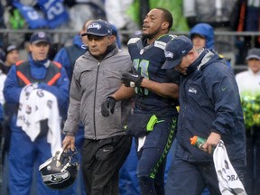 Wide receiver Percy Harvin of the Seattle Seahawks is helped off the field late in the second quarter against the New Orleans Saints during the NFC Divisional Playoff Game at CenturyLink Field on January 11, 2014 in Seattle, Washington.  Harry How/Getty Images/AFP