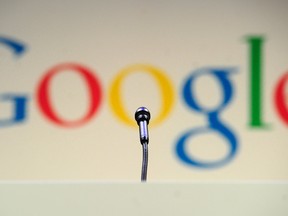 A microphone stands in front of a Google logo during a press announcement at Google headquarters in New York, May 21, 2012. (AFP PHOTO/Emmanuel Dunand/FILES)