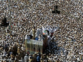 Indian Bohra Muslims take part in the funeral procession of their spiritual leader Syedna Mohammed Burhanuddin in Mumbai on January 18, 2014. A stampede killed at least 18 people in India's financial hub Mumbai as a large crowd gathered to pay their last respects to a Muslim spiritual leader, police said. More than 40 were also injured in the chaos that erupted shortly after midnight. AFP PHOTO/ PUNIT PARANJPE