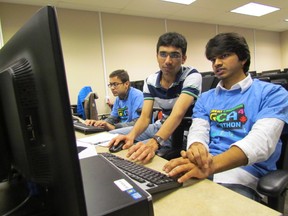 Lambton College students, from left, Punit Shah, Viren Gujariya and Bhanu Chander Reddy work on their team's mobile game app during the weekend's Great Canadian Appathon. Lambton College had four teams in the national, 48-hour programming competition. (PAUL MORDEN, The Observer)