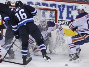 Edmonton Oilers goaltender Ilya Bryzgalov tracks a puck through a crowd in front of his net during NHL action against the Winnipeg Jets at MTS Centre in Winnipeg, Man. on Sat., Jan. 18, 2014. (Kevin King/Winnipeg Sun/QMI Agency)