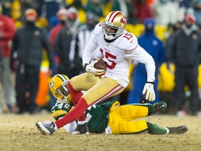 San Francisco 49ers wide receiver Michael Crabtree (15) is tackled by Green Bay Packers cornerback Jarrett Bush (24) after catching a pass during the fourth quarter of the 2013 NFC wild card playoff football game at Lambeau Field. (Jeff Hanisch-USA TODAY Sports)