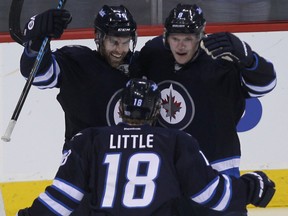 Bryan Little, Andrew Ladd (left) and Jacob Trouba of the Winnipeg Jets  celebrate Trouba's third-period goal against the Edmonton Oilers during NHL action at MTS Centre in Winnipeg, Man. on Sat., Jan. 18, 2014. Kevin King/Winnipeg Sun/QMI Agency