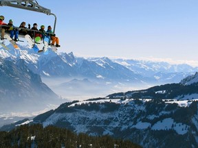 Skiers sit in a chairlift at the Flumserberg skiing area in the eastern Swiss Alps February 27, 2013.  REUTERS/Arnd Wiegmann