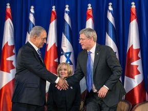 Israel's Prime Minister Benjamin Netanyahu, left, shakes hands with his Canadian counterpart Stephen Harper as Harper's wife Laureen watches during a welcoming ceremony for Harper at Netanyahu's office in Jerusalem on January 19, 2014. (REUTERS/Baz Ratner)