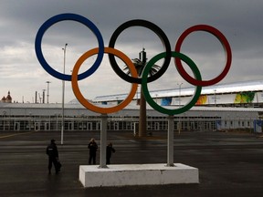 A police officer (L) stands near Olympic rings at the Olympic Park in the Adler district of Sochi  on Jan. 18, (REUTERS)